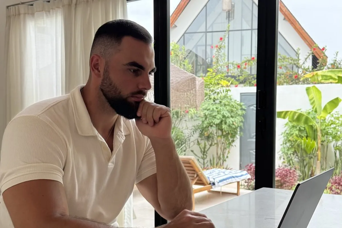Kamil Owsianik, trener personalny, przy laptopie podczas konsultacji online